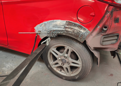 Red car bumber being fixed