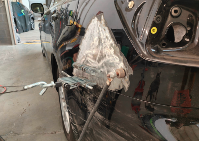 Black car dent being pulled out