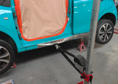 Blue car dent being pulled